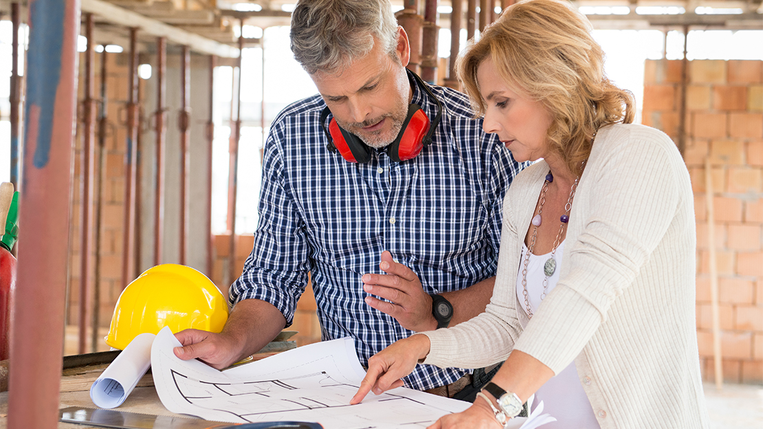 Två personer tittar på planritning