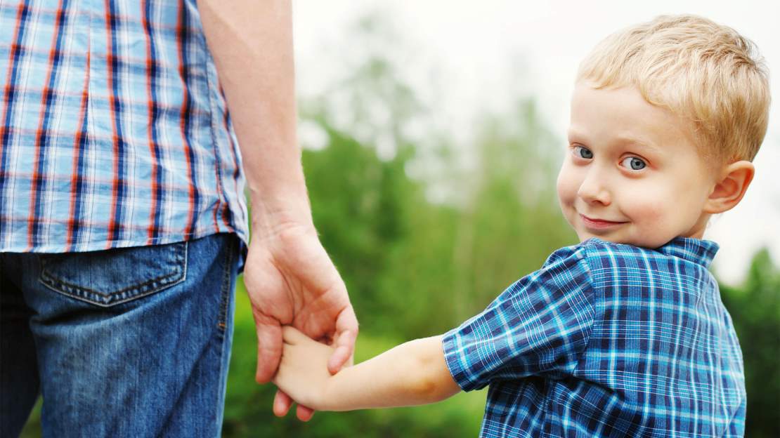 Pojke håller pappas hand
