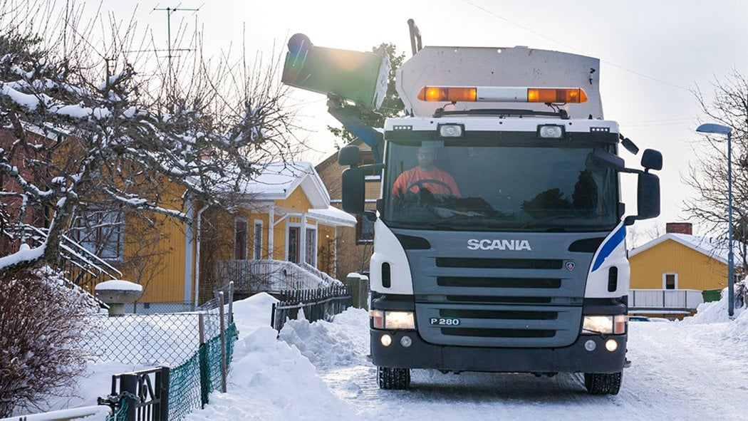 Sopkärl töms i sopbil på vinterväg
