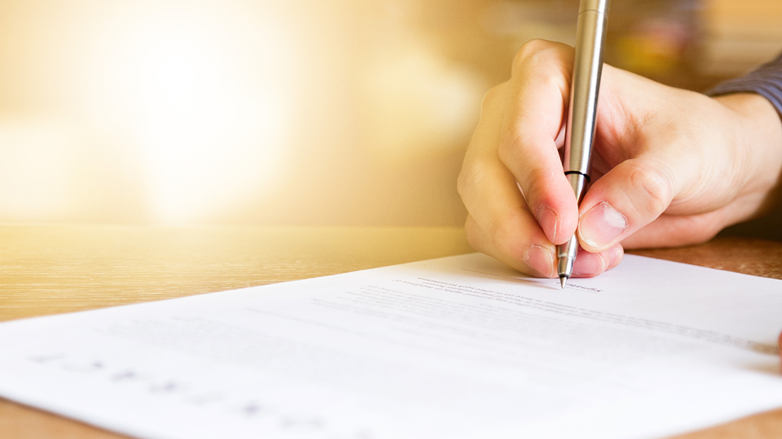 Person signerar ett dokument