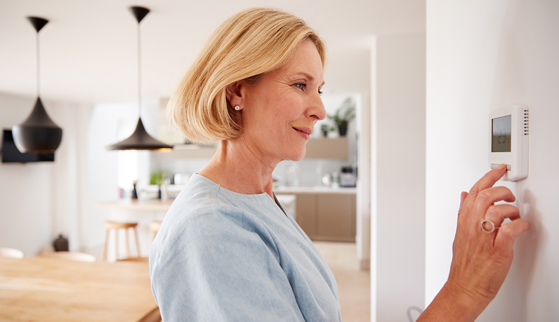 kvinna reglerar temperaturen