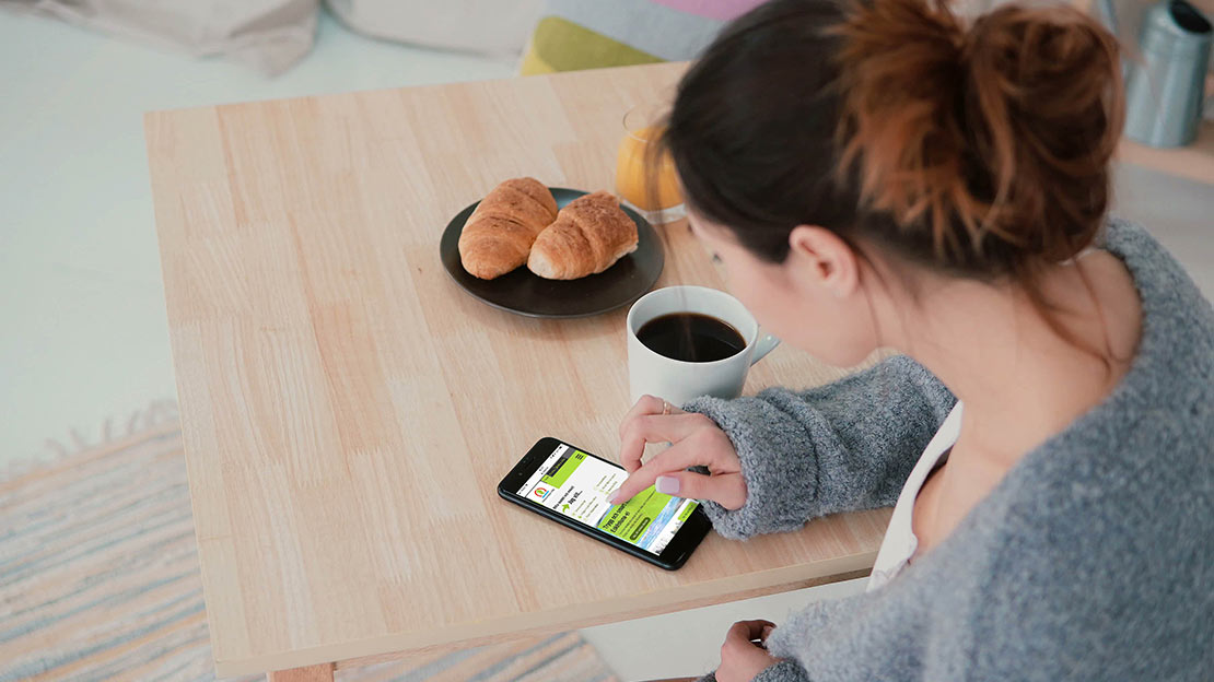 Kvina surfar på EEMs hemsida på mobilen 