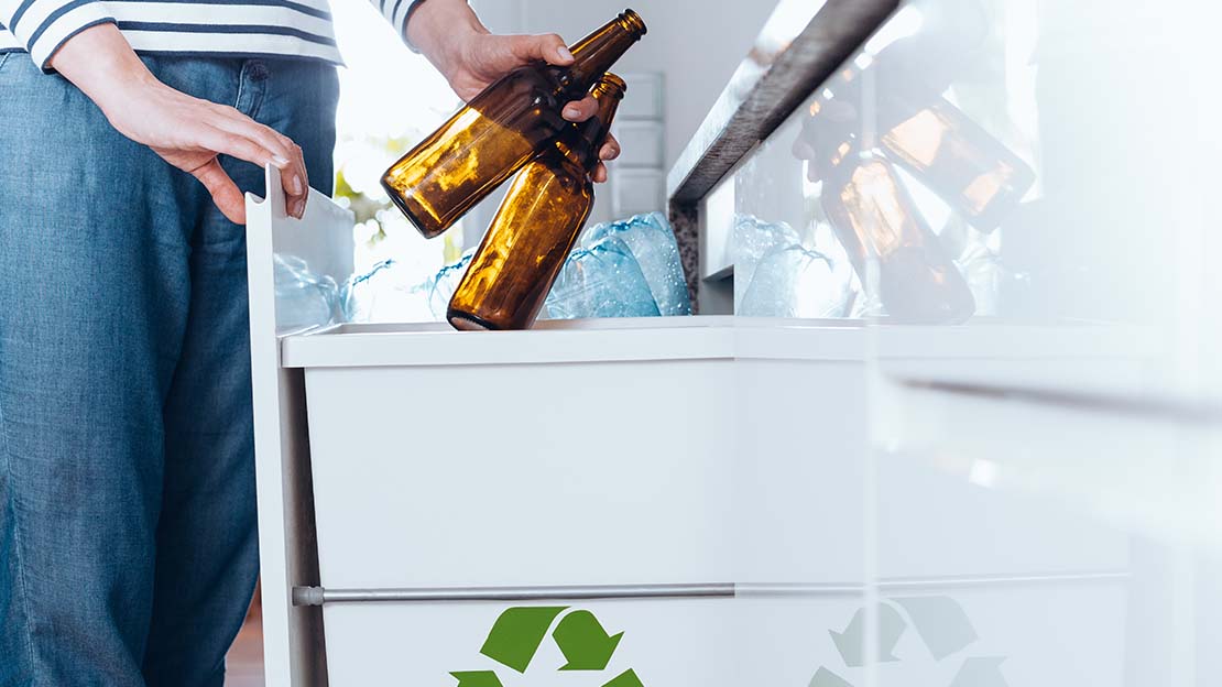 Person sopsorterar flaskor