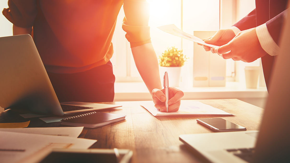 Två personer på en arbetsplats med varsin laptop