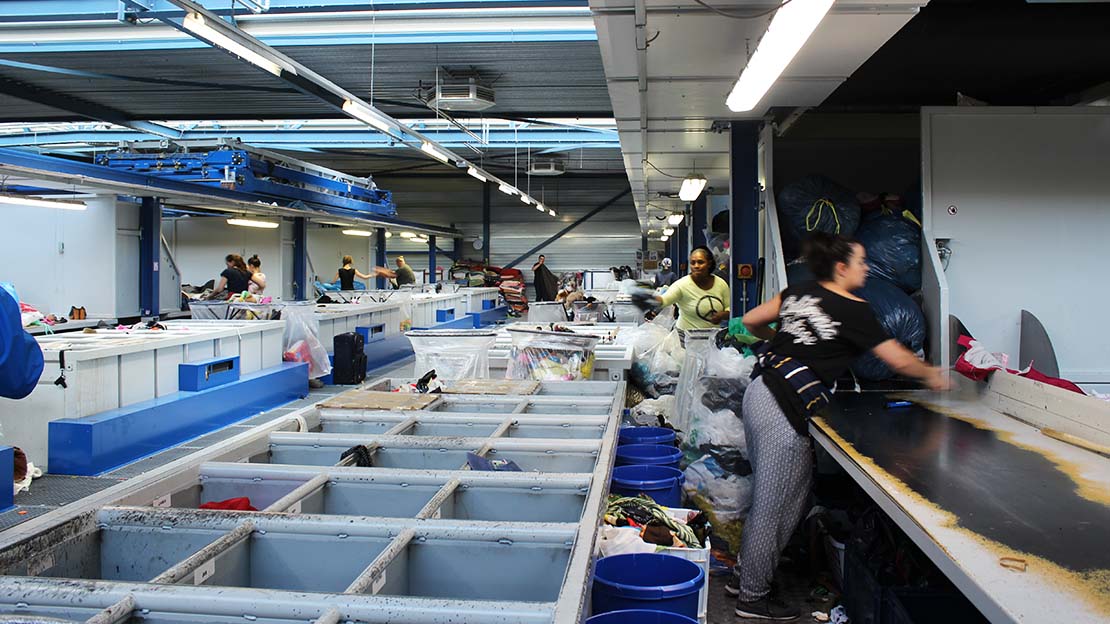 Textilier sorteras i återvinningsanläggning