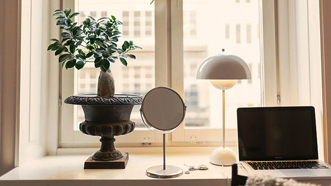 Lägenhetsfönster som arbetsplats med laptop