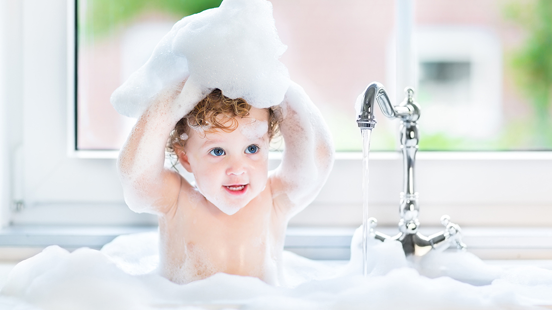 Barn leker med lödder i badkar